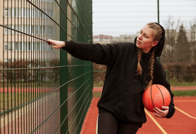 Teenager playing basketball outdoors