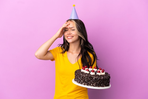 Teenager Russian girl holding birthday cake isolated on purple background smiling a lot