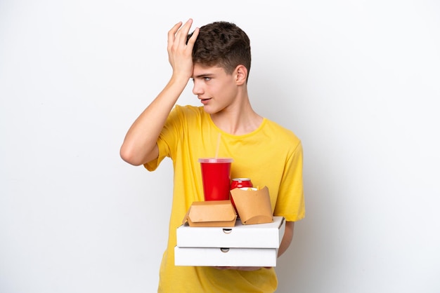 Teenager Russian man holding fast food isolated on white background has realized something and intending the solution