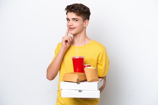 Teenager Russian man holding fast food isolated on white background thinking an idea while looking up