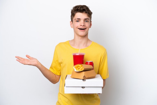 Teenager Russian man holding fast food isolated on white background with shocked facial expression