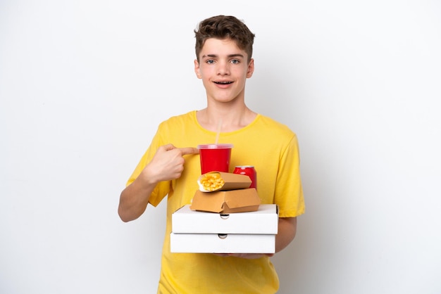 Teenager Russian man holding fast food isolated on white background with surprise facial expression