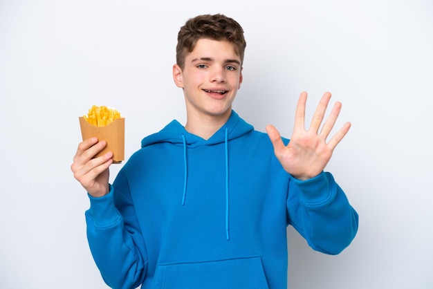 Teenager Russian man holding fried potatoes isolated on white background counting five with fingers