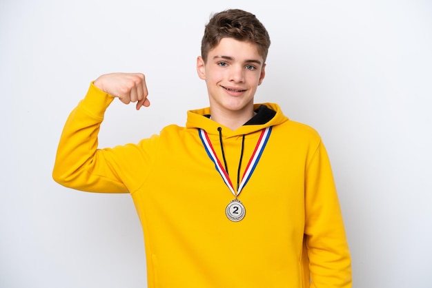 Teenager Russian man with medals isolated on white background doing strong gesture