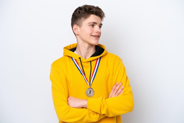 Teenager Russian man with medals isolated on white background happy and smiling