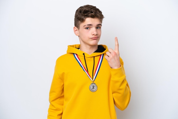 Teenager Russian man with medals isolated on white background pointing with the index finger a great idea