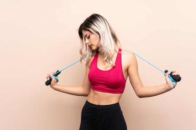 Teenager sport girl over isolated background with jumping rope