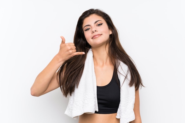 Teenager sport girl over isolated white wall making phone gesture