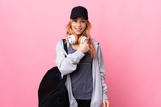 Photo teenager sport woman with sport bag over isolated wall celebrating a victory