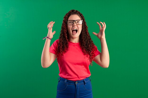 Teenager wearing glasses in fun poses in a studio photo with a green background ideal for cropping