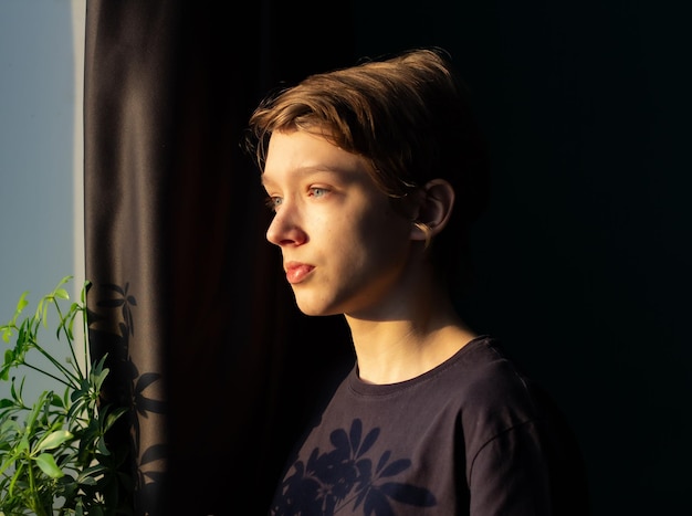 teenager at the window, pensive