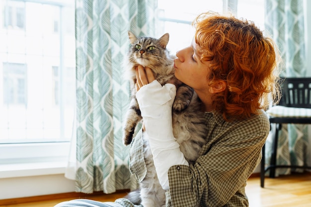 Teenager with broken arm in cast and pet cat