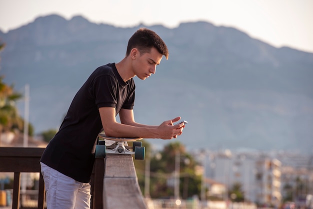 Teenager with his long board in promenade