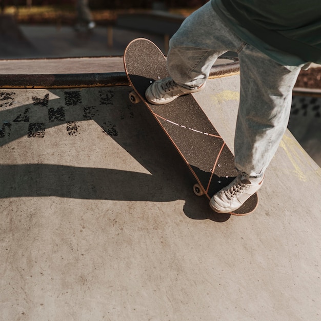 Teenager with skateboard having fun at the skatepark with copy space