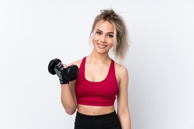 Teenager woman holding waffles over isolated blue wall making weightlifting