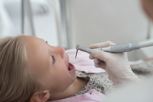 Teeth treatment. A little blonde child having teeth treatment at the dentists