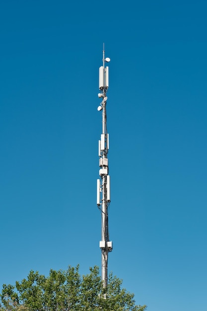 Telecommunication cell tower antenna against blue sky