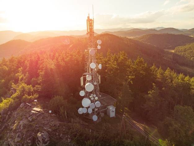 Telecommunication mast television antennas on mountains at sunset