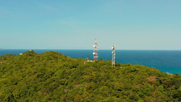 Telecommunication tower communication antenna in tropical island aerial view repeaters on a metal to