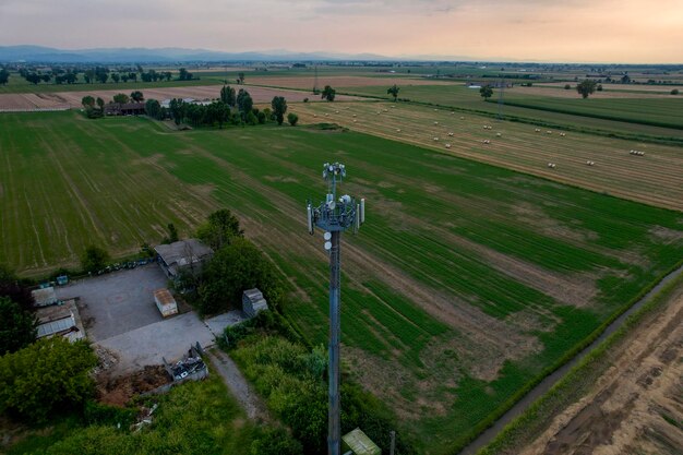 Photo telecommunication tower providing signal in rural landscape at sunset