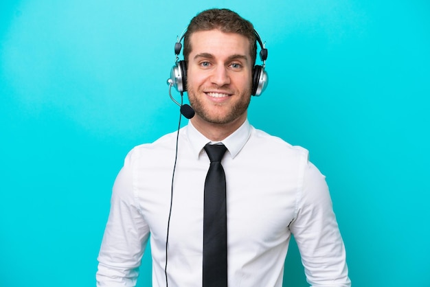 Telemarketer caucasian man working with a headset isolated on blue background laughing