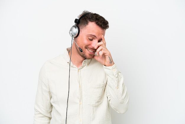 Telemarketer caucasian man working with a headset isolated on white background laughing