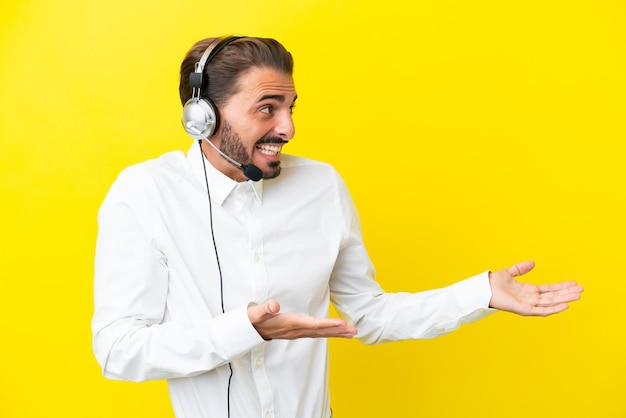 Telemarketer caucasian man working with a headset isolated on yellow background with surprise facial expression