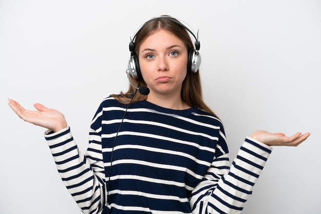 Telemarketer caucasian woman working with a headset isolated on white background having doubts while raising hands