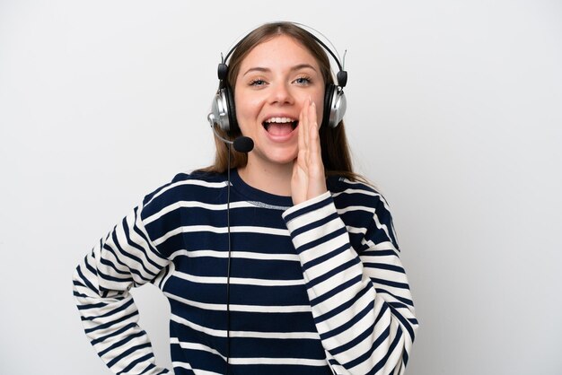 Telemarketer caucasian woman working with a headset isolated on white background shouting with mouth wide open