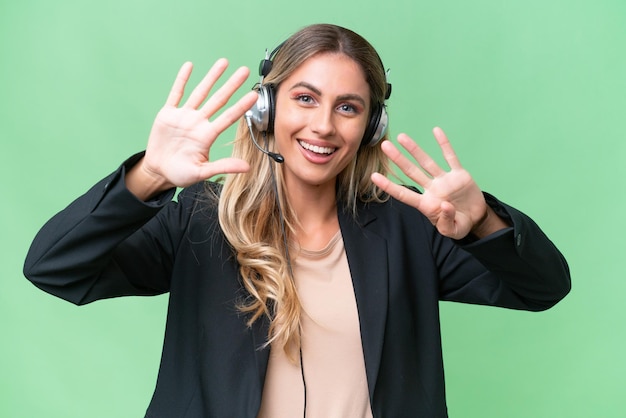 Telemarketer pretty Uruguayan woman working with a headset over isolated background counting nine with fingers