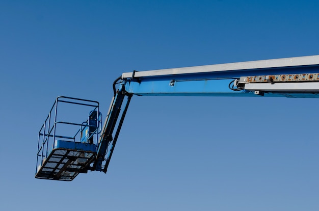 Telescopic boom lift raised up on blue sky background delivered