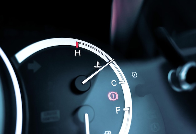 Temperature gauge indicator on car instrument panel and caution light illuminated automotive part concept