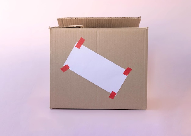 A template for writing on a cardboard box with a white piece of paper glued with red tape