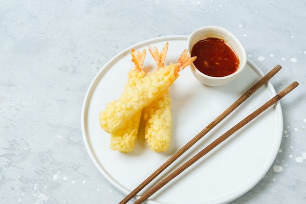 Tempura shrimp with sweet chili sauce on a white plate. Asian cuisine food delivery