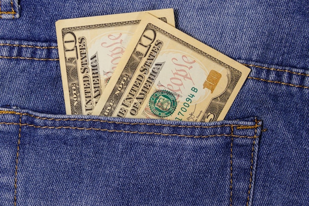 Ten dollars banknote in the pocket of blue jeans