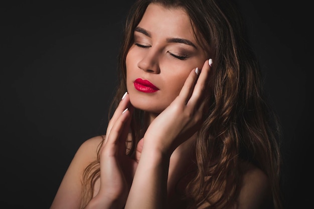 Tender brunette woman with closed eyes.Studio shot