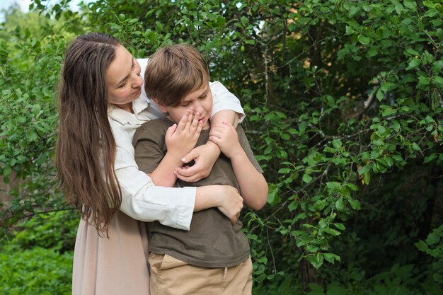 Photo a tender embrace as a mother comforts her upset son showcasing maternal support and a child s