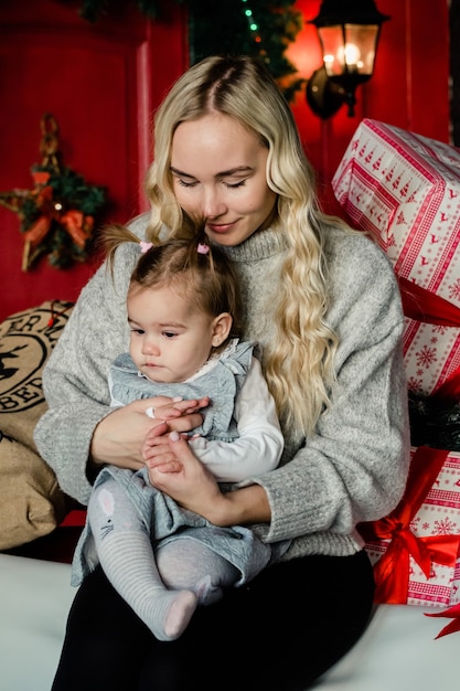 Tender pretty mom hugs her daughter on christmas background. Family Holiday, Presents, Christmas, X-mas concept