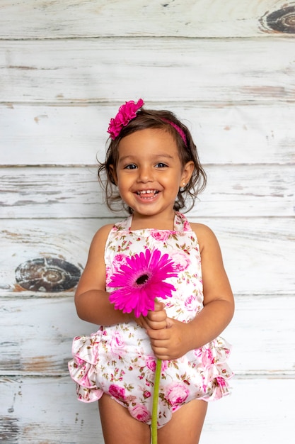 Tender smiling toddler, with a flower in her hand