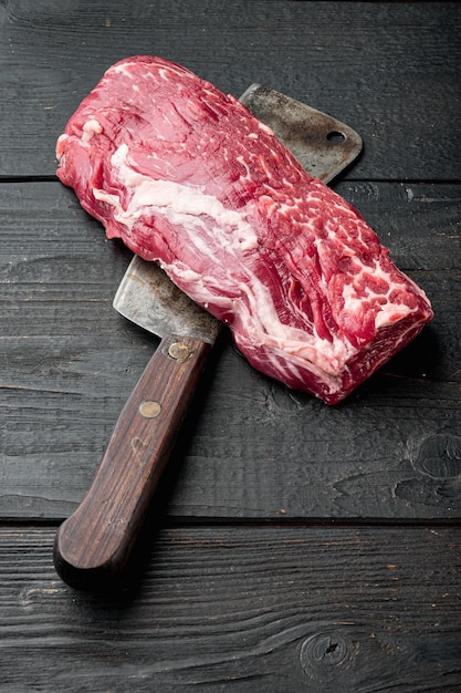 Tenderloin, or Eye Fillet cut raw marbled beef meat set , with old butcher cleaver knife, on black wooden table background