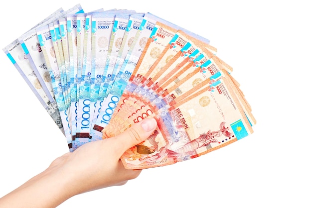 Tenge. The female hand holds many Kazakh bills on a white background close-up.