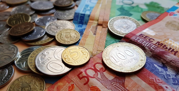 Tenge. Money. Kazakh coins and bills are on the table close-up.