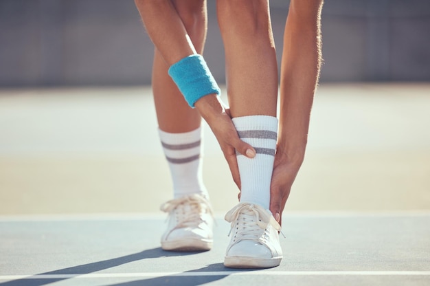 Tennis athlete with ankle injury pain and hurt on a court after training workout or practice outdoor Professional sport person with accident after fitness exercise game or match at a sports club