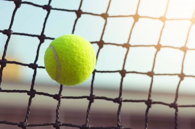 Tennis ball hitting to net on blur court background 