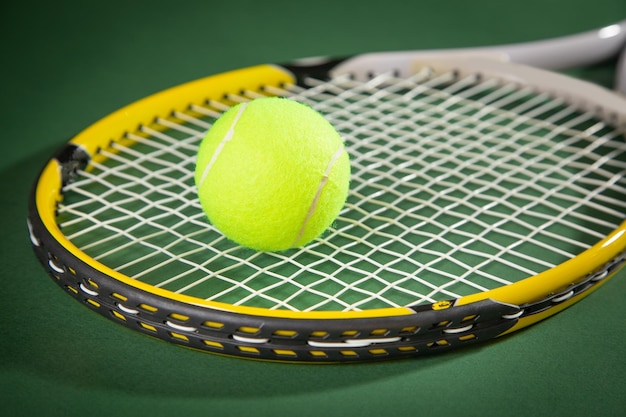 Tennis ball and racket on the green background