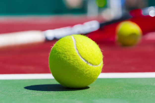 Tennis balls and racket on the grass court