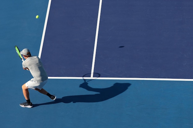 A tennis player is about to hit the ball with his racket