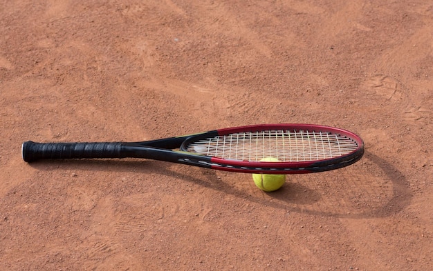 Tennis racket and balls on the clay court