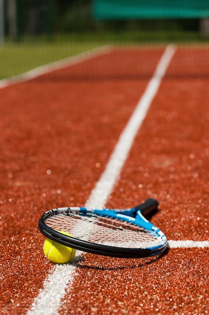 Tennis time. Close-up of tennis racket and tennis ball laying on the court