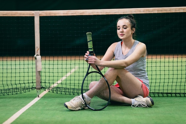 Tennis woman player playing training with racket and ball at court